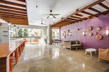 A room with a purple wall and a ceiling fan.